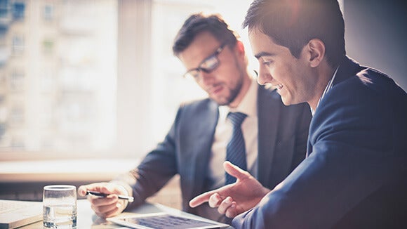 two men discussing two men discussing and pointing to the tablet