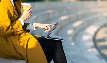 woman with laptop and coffee outside
